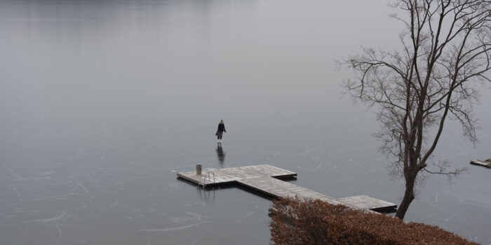 widok zamarzniętego jeziora Wulpińskiego, pomost i łyżwiarz